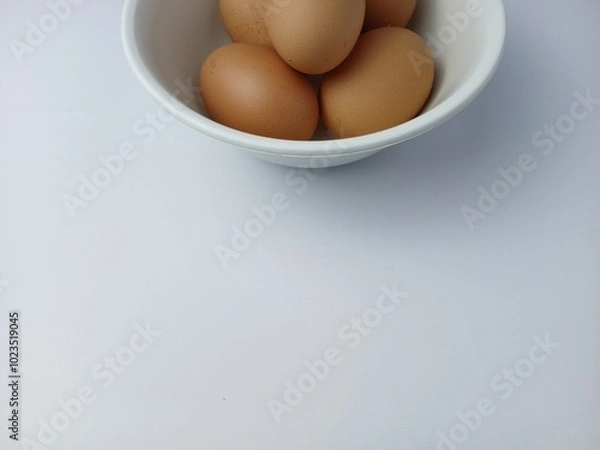 Fototapeta Group of brown raw eggs on a bowl, with copy space for text  isolated on white background