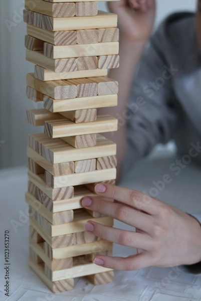 Obraz Board games; close-up of a hand building a tower of wooden blocks