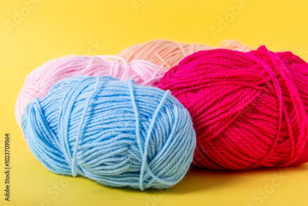 Fototapeta Multicolored yarn balls on yellow background. Yarn for knitting