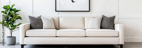 Fototapeta A white sofa with black and white throw pillows in a modern living room.