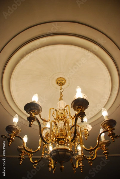 Obraz Large chandelier with candle shaped lights in a dark room