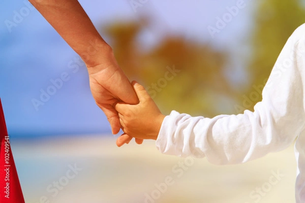 Fototapeta mother and son holding hands on beach