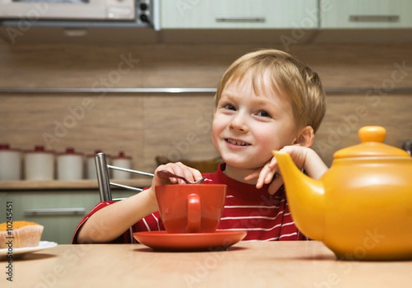 Obraz Child drinks tea with cakes