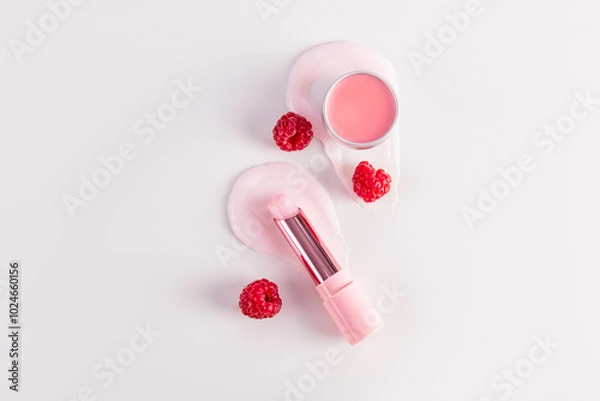 Fototapeta Cosmetic balm in a tube and round jar with a delicate structure on a pink background for lip care. A unique berry complex. Pleasant raspberry aroma.
