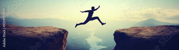Fototapeta Silhouette man jumping over cliffs for I can do it, good mindset, freedom, good mindset, photo, poster, conceptual art, success, goals 
