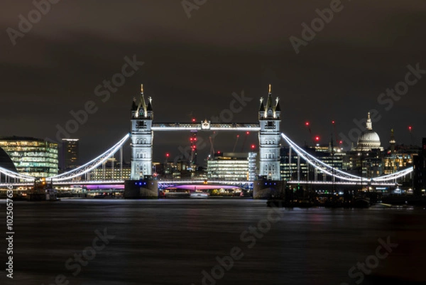 Fototapeta Tower Bridge in London at night, looking upriver towards the centre  of London with St Pauls in the background