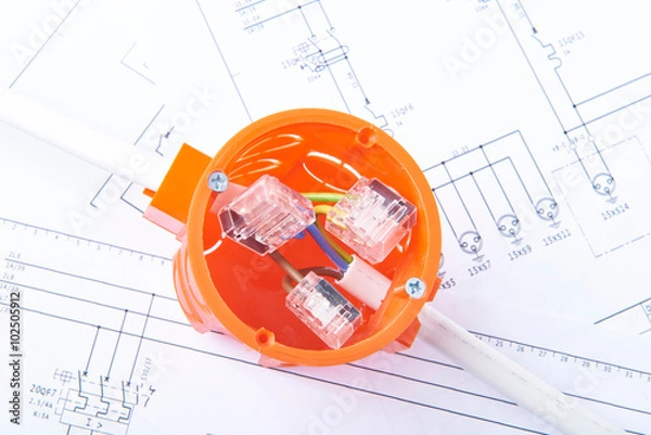 Fototapeta Cable connections in electrical junction box, lying on electrical diagrams. Concept of energy works.
