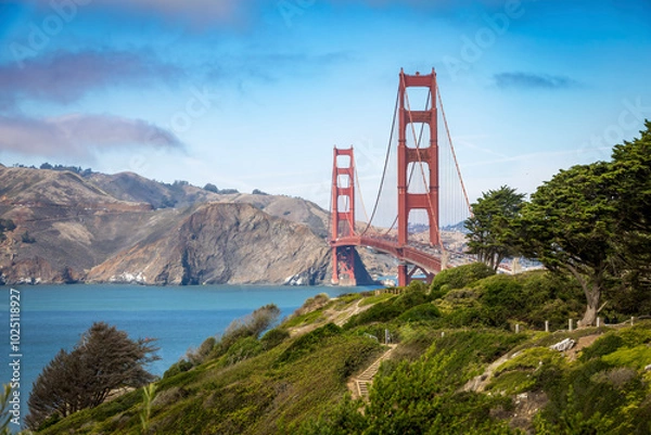 Fototapeta A stunning view of the Golden Gate Bridge surrounded by lush greenery and the calm waters of the San Francisco Bay.