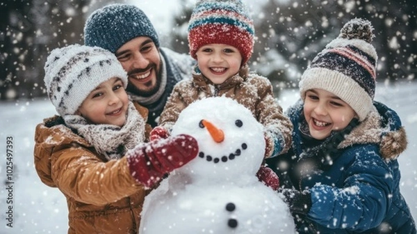 Fototapeta Parents and two children building a snowman together, everyone smiling and focused on adding final touches to the snowman
