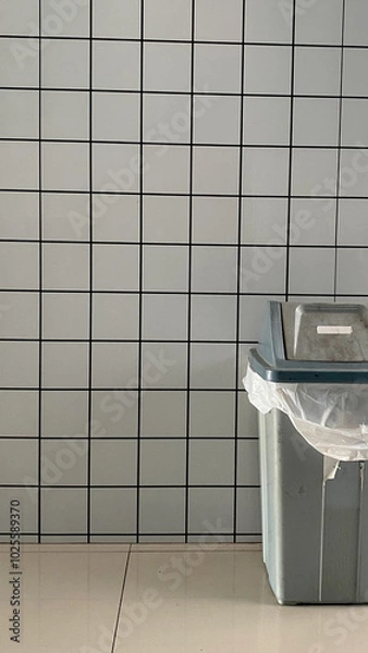 Obraz white checkered walls, with a trash can in the corner
