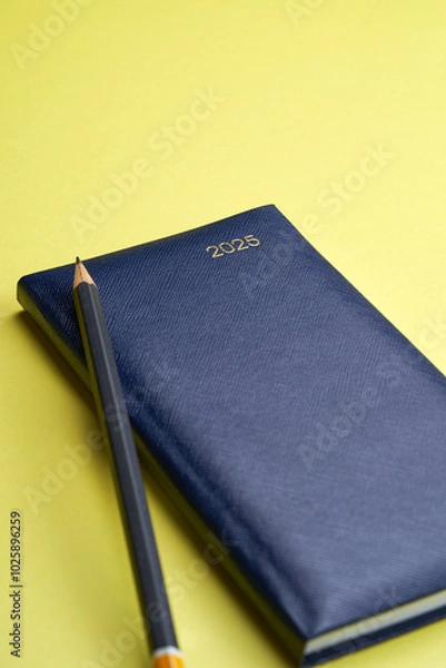 Fototapeta diary 2025  and pencil on the yellow background