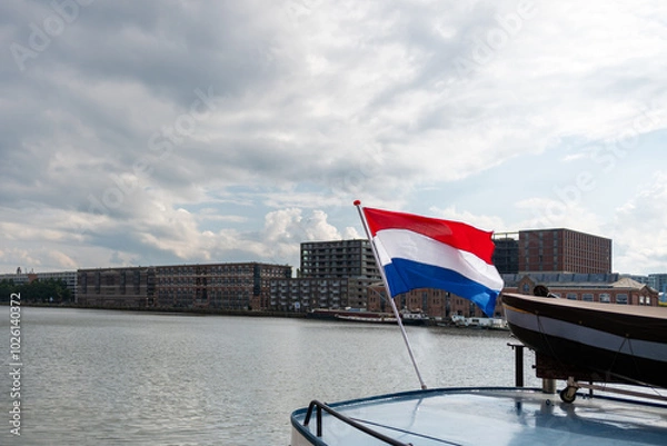 Fototapeta The flag of the Netherlands fluttering in the wind. Red, White and Blue. National pride and unity. The spirit of patriotism in Holland. Sky, water or buildings in the background.