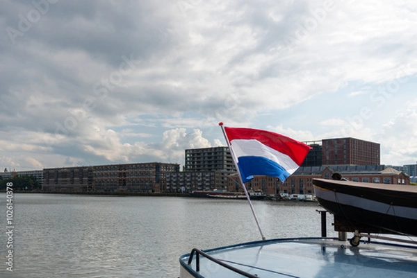 Fototapeta The flag of the Netherlands fluttering in the wind. Red, White and Blue. National pride and unity. The spirit of patriotism in Holland. Sky, water or buildings in the background.