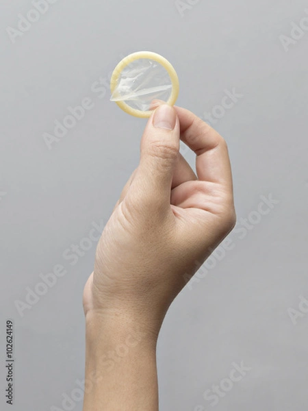 Obraz Female hand holding condom