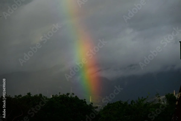 Fototapeta A rainbow after the rain. Natural phenomenon background material.
