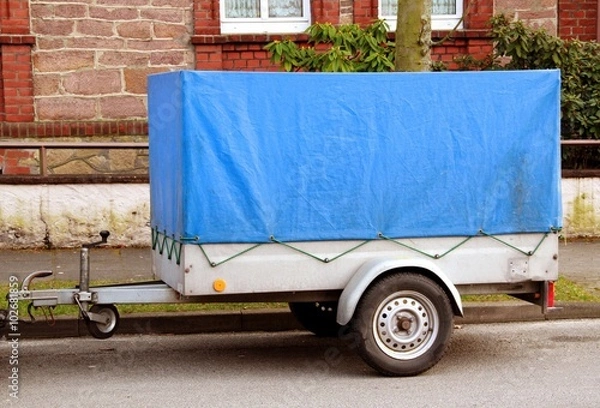 Obraz Einachsiger Anhänger mit blauer Plane für PKWs
