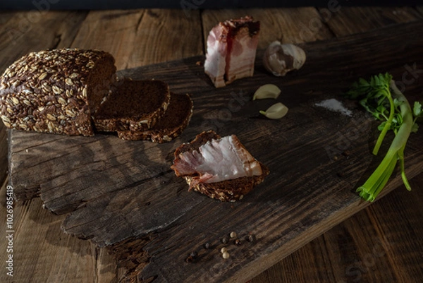 Obraz Snack with dark bread and lard. Sandwich with dark bread and bacon. Snack country style Low key.
