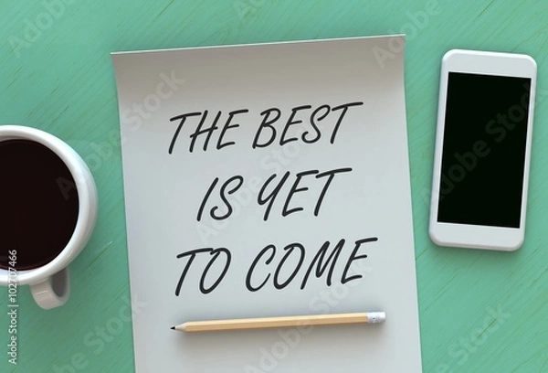 Fototapeta The Best is Yet to Come, message on paper, smart phone and coffee on table