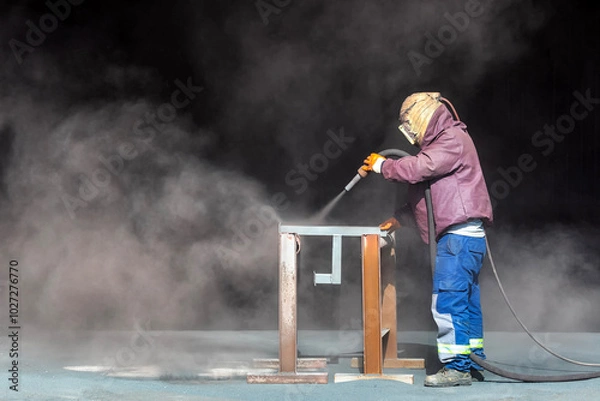 Fototapeta Sandblasting or abrasive blasting. Which is a generic term for the process of smoothing, shaping and cleaning a hard surface by forcing solid particles across that surface at high speeds.