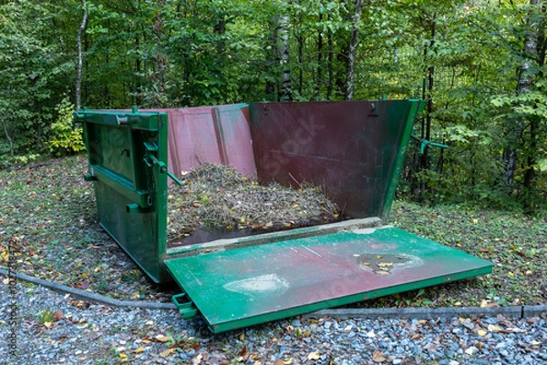 Fototapeta Bulky iron container for bio waste in a forest park.