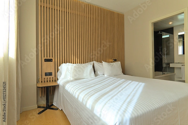 Obraz Bright Hotel Room with Wooden Decor and Direct Bathroom View