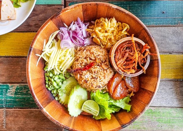 Fototapeta khao kluk kapi or shrimp paste fried rice more ingredient slice cow pea and sour mango cooking with sausage. mixed red onion and fried shrimp. thailand street food sweet pork sauce yummy omelet egg