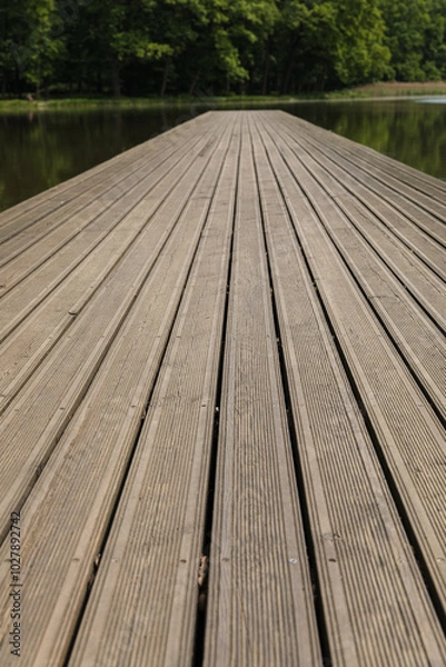 Fototapeta Wooden pier on the lake, symmetrical shot, leading lines made of planks.