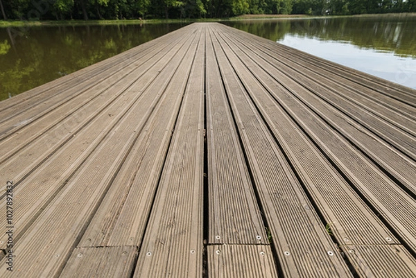 Fototapeta Wooden pier on the lake, symmetrical shot, leading lines made of planks.