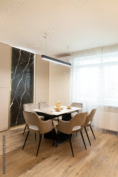 Fototapeta Modern apartment interior featuring a stylish dining area with sleek design elements and natural light in an inviting space