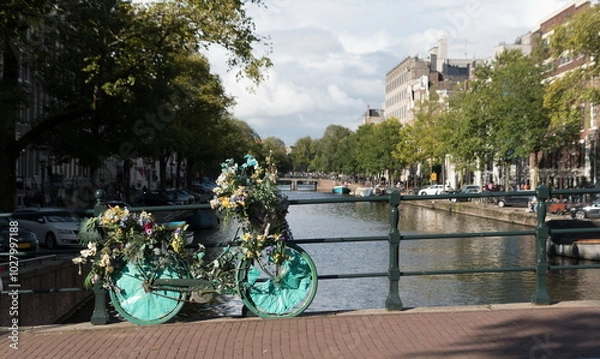 Obraz Bicycle covered by decorative garlands on a bridge in Grachtengordel