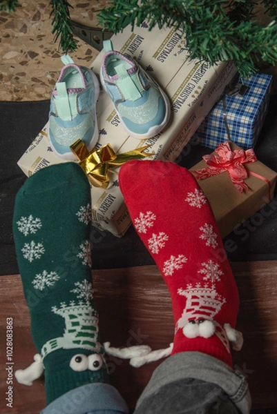 Obraz Two feet in funny socks holding “hands”