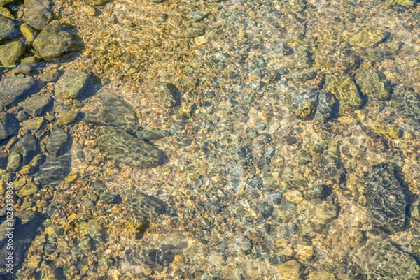 Obraz Clear Riverbed. Close up of a riverbed showing clear water flowing over smooth stones and pebbles. 