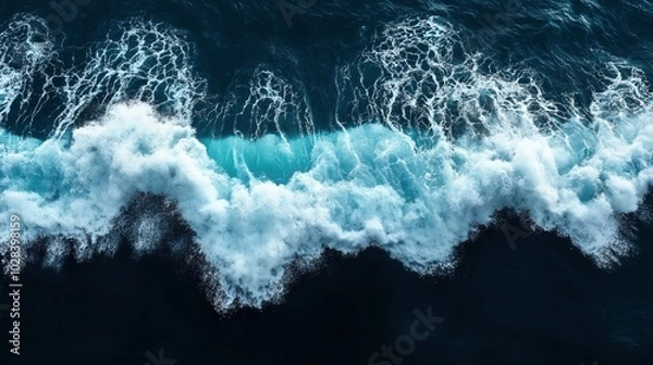 Fototapeta Aerial view of ocean waves crashing with white foam on deep blue water creating dynamic sea patterns and textures.