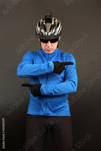 Fototapeta male cyclist in top form indicates his hands in different direct