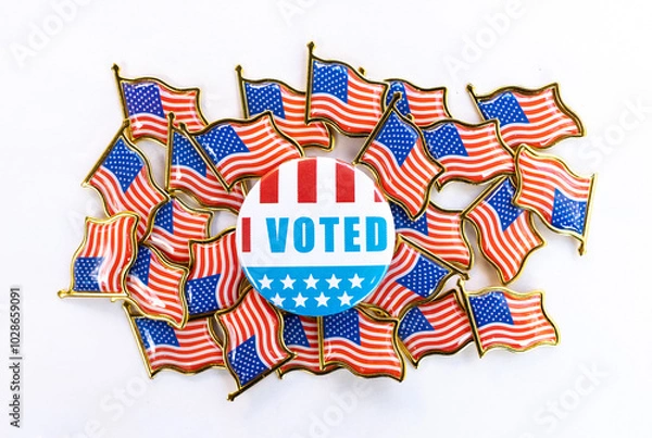 Fototapeta I Voted button with American flags background A circular "I Voted" button displayed in the center of multiple small American flag pins highlights patriotic colors, emphasizing the importance of voting