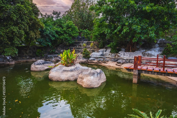 Fototapeta Japanese pond with bridge in the park in the garden at the Buddhist pagoda in summer in Asia