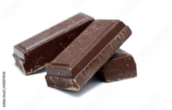 Fototapeta Heap of the pieces of dark chocolate on white background.