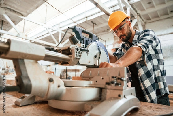 Fototapeta Focused, woodworking. Man is in warehouse