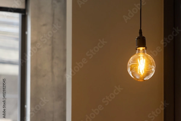 Obraz A vintage light bulb hanging from a ceiling.