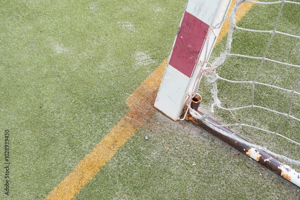 Fototapeta image of a real sports field with marked lines and part of the white-red goal. The surface of the handball or football field is made of green artificial carpet.