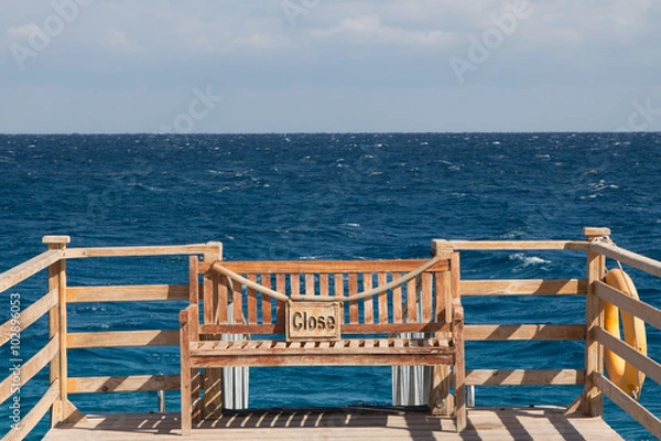 Fototapeta Bench on a pier with the plate "close"