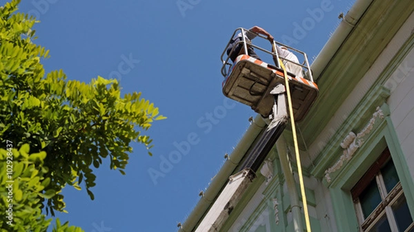Obraz Construction Workers on Hydraulic Platform