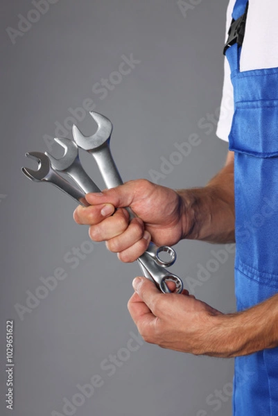 Obraz Auto mechanic with wrenches on grey background, closeup