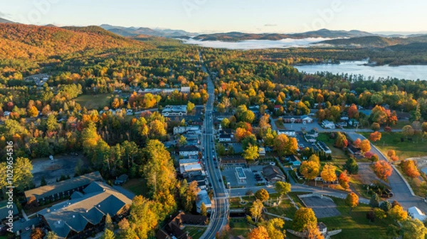Obraz Aerial view of Schroon Lake, NY, with vibrant autumn colors, tree-lined streets, and surrounding Adirondack Mountains, showcasing the small town's scenic charm and peaceful lakeside setting.
