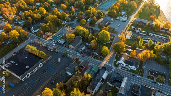 Obraz Aerial view of Schroon Lake, NY, highlighting the charming small town, vibrant autumn trees, and peaceful lakeside setting under the warm golden light of late afternoon.