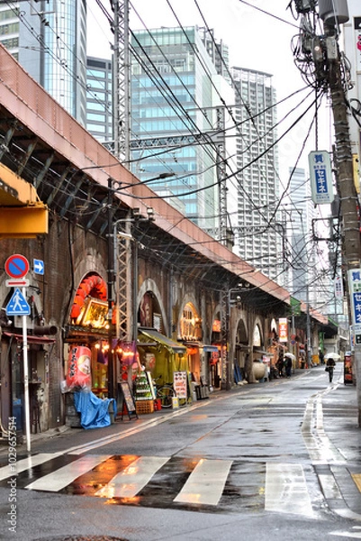 Obraz 雨の日の新橋駅烏森口から眺めるガード下飲食店街の様子