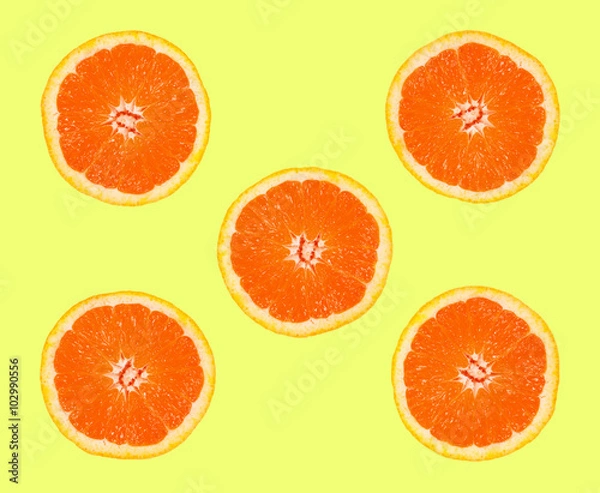 Fototapeta slices of grapefruit on a yellow background