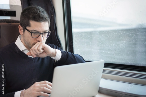 Fototapeta man working with computer on a train
