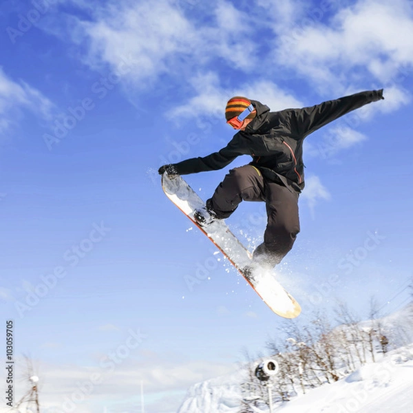 Fototapeta Snowboarder doing high jump above the mountain