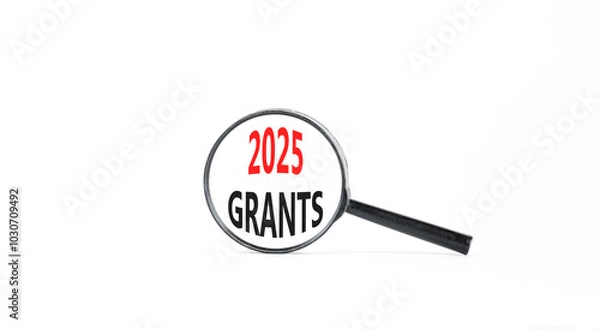 Fototapeta Planning 2025 grants new year symbol. Concept words 2025 Grants on beautiful white paper in magnifying glass. Beautiful white paper background. Business 2025 grants new year concept. Copy space.